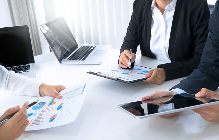 personas analizando gráficos financieros y reportes en dispositivos digitales