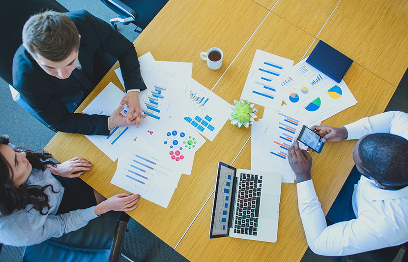 profesionales con documentos y laptop haciendo análisis de logística y comercio internacional