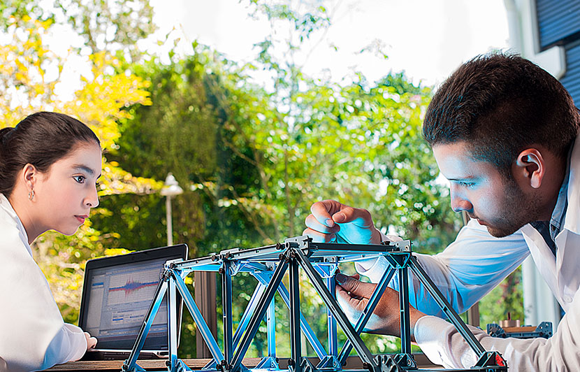 profesionales haciendo simulación de diseño estructural en laboratorio de ingeniería civil