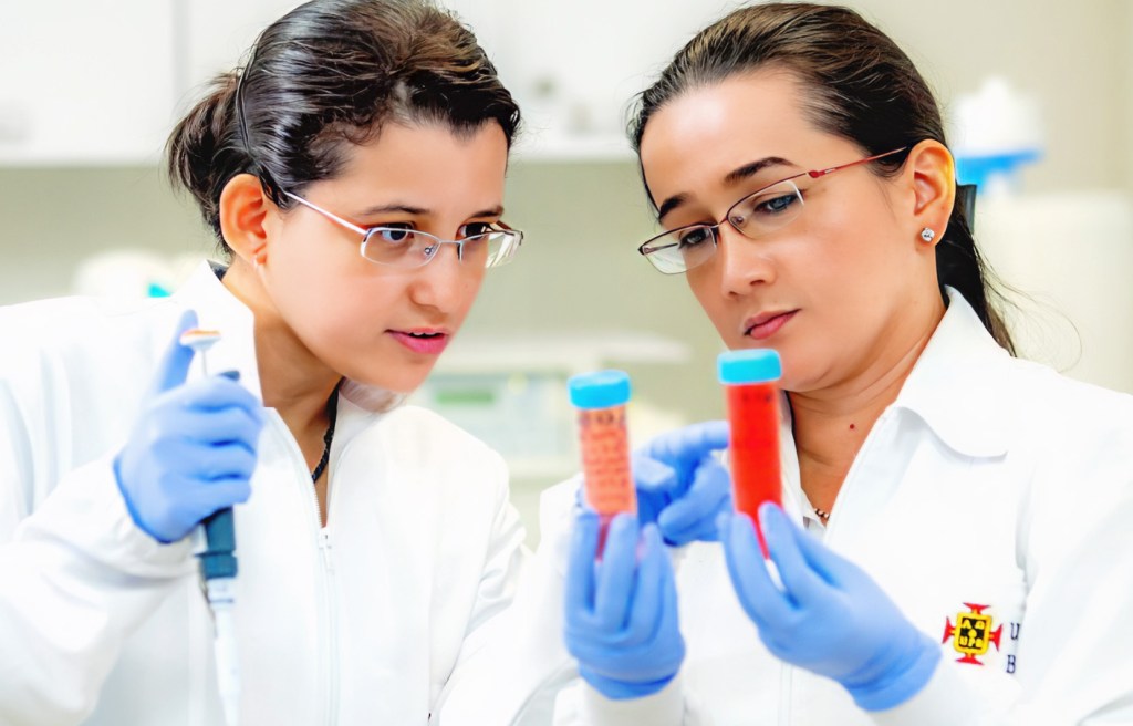 dos investigadoras en laboratorio de ingeniería química con instrumentos de análisis