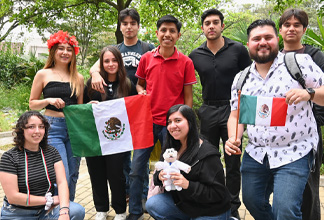  grupo de personas sosteniendo banderas de México en un espacio al aire libre con árboles