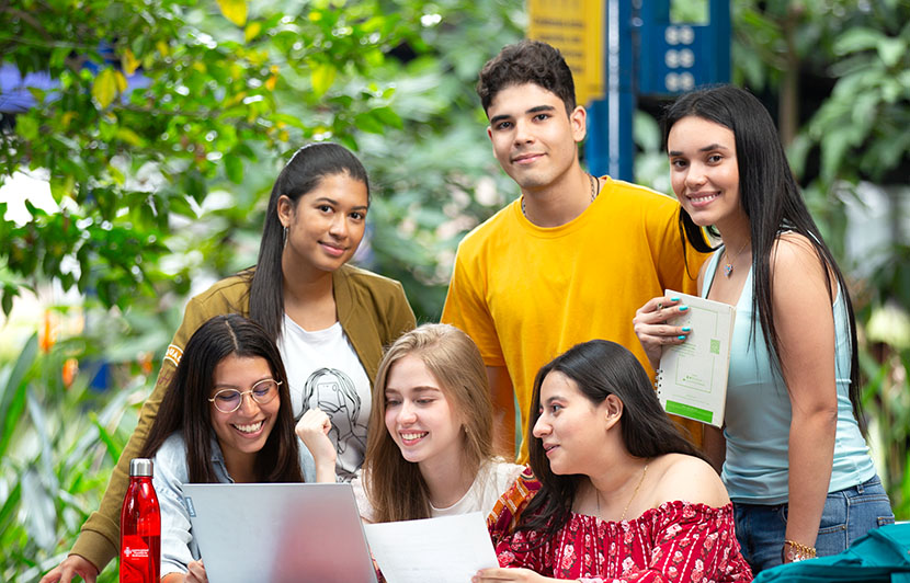 grupo académico del programa de psicología revisando apuntes y laptop