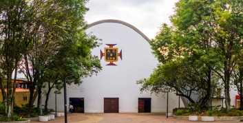 fachada templo universitario con logo upb en área abierta con jardines