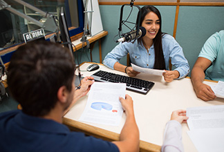 personas en cabina de radio realizando transmisión en vivo