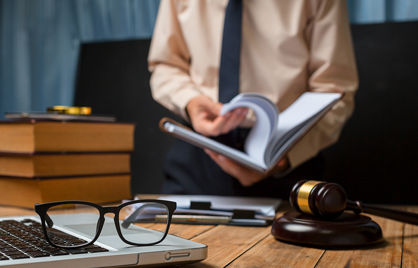mesa de trabajo con libros, mazo judicial y documentos para análisis jurídico