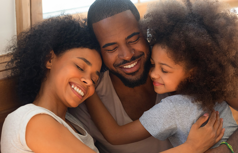 abrazo entre padres e hija mostrando protección y cuidado