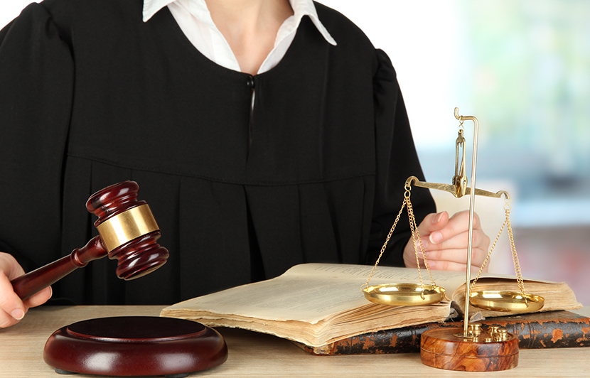 mazo judicial y balanza sobre escritorio con libro abierto