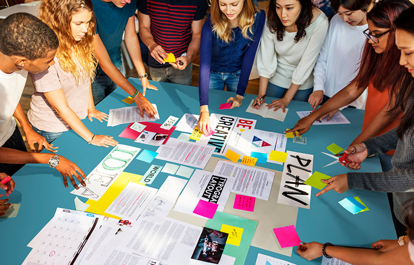 equipo multidisciplinario desarrollando ideas con documentos en una mesa