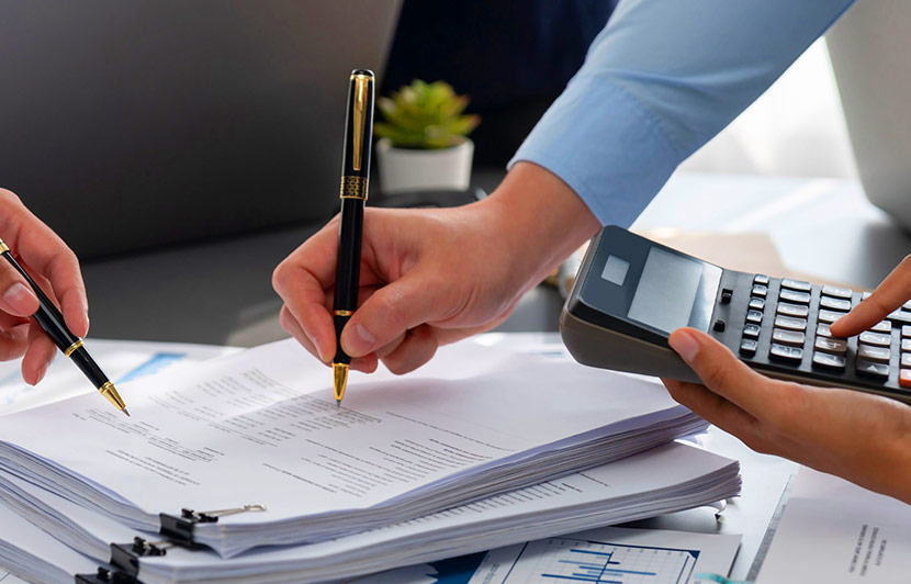 revisión de documentos tributarios con calculadora y gráficos financieros