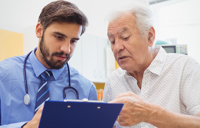 profesional de la salud revisando información médica con paciente adulto mayor