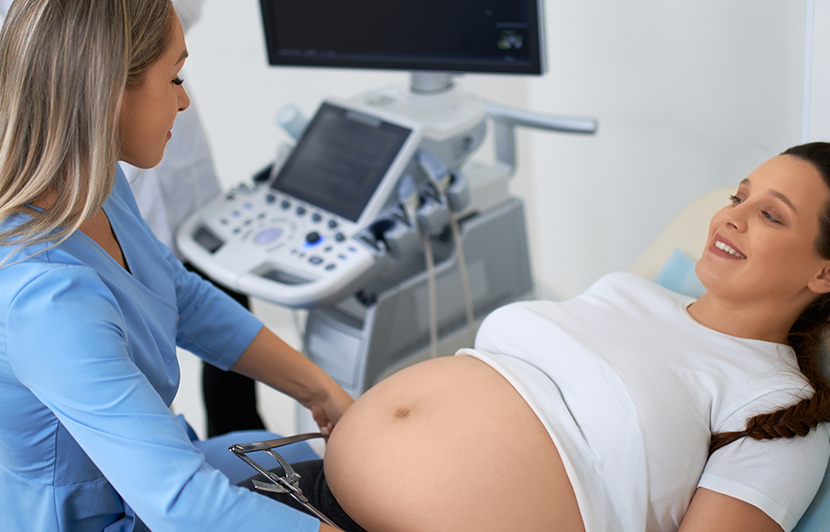 profesional de la salud realizando ecografía a mujer embarazada