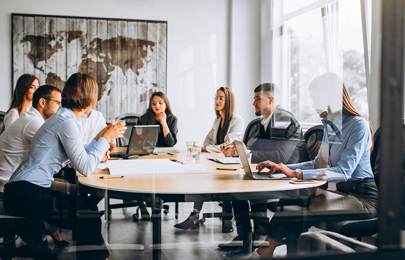 equipo en mesa de trabajo con laptops y documentos en reunión corporativa