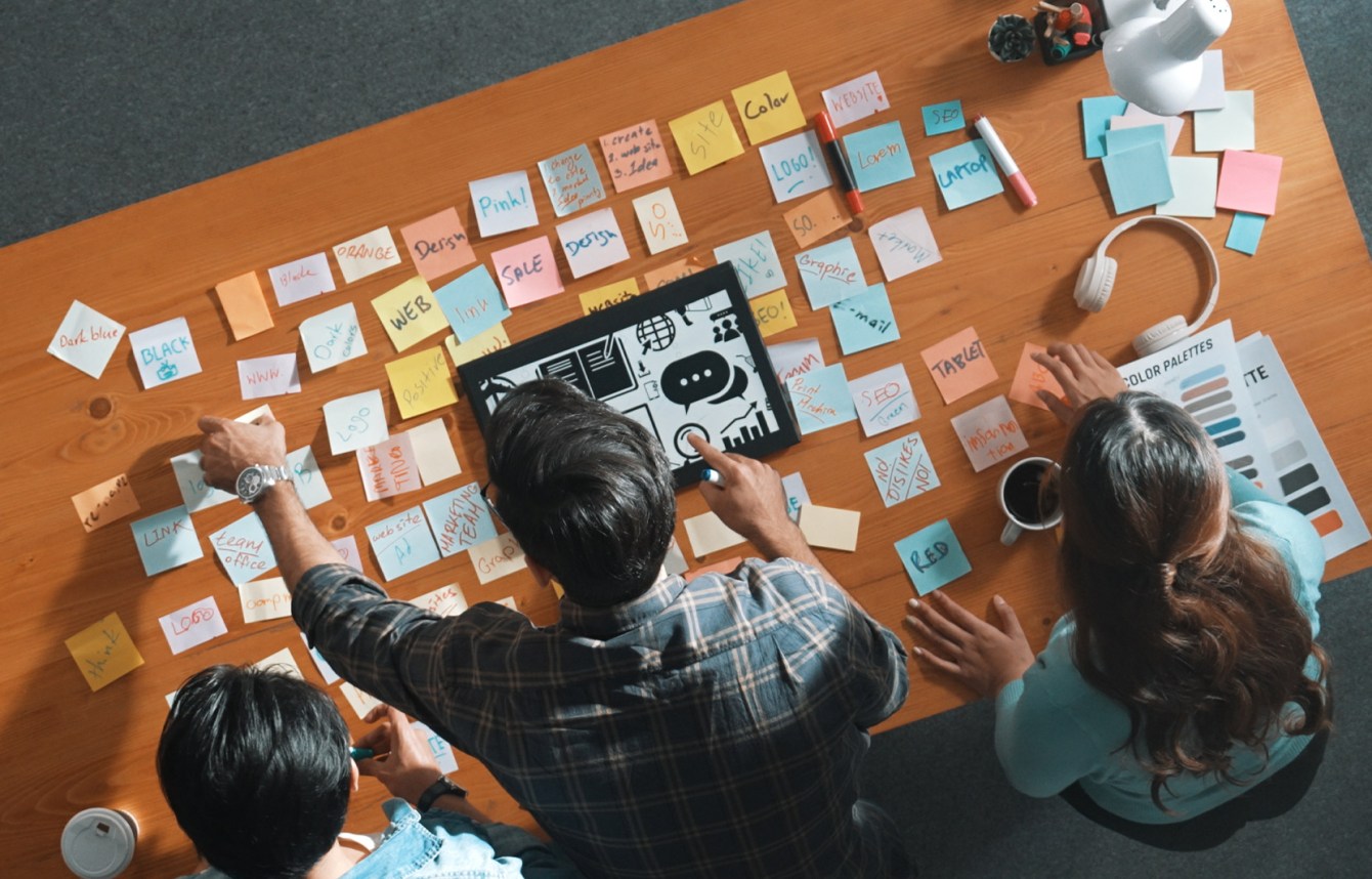 sesión de brainstorming sobre comunicación con equipo creativo equipo de trabajo organizando ideas con notas adhesivas sobre una mesa