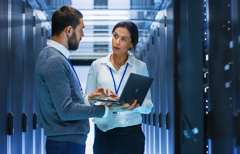 profesionales de seguridad informática con portátil dentro de un centro de datos