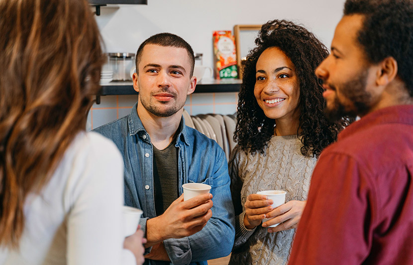 personas conversando mientras toman café en un espacio de trabajo