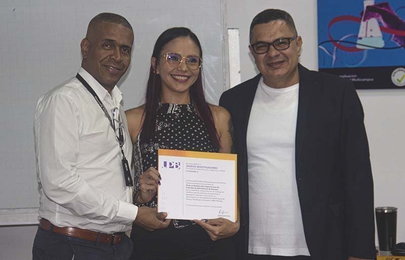 Docente Paola Salazar con su reconocimiento al Grupo de Investigación, Estudios sobre Organizaciones