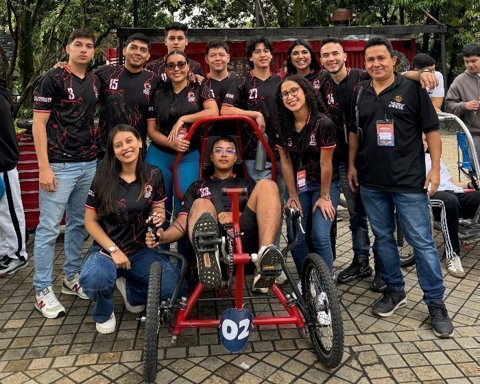 Jóvenes reunidos con su proyecto de carros VTH participando en una competencia en Medellín