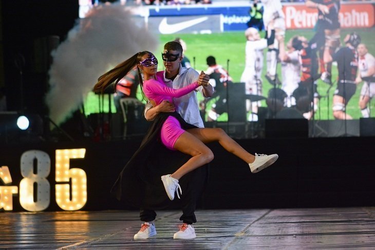 dos estudiantes bailando con movimientos donde la joven esta alzada
